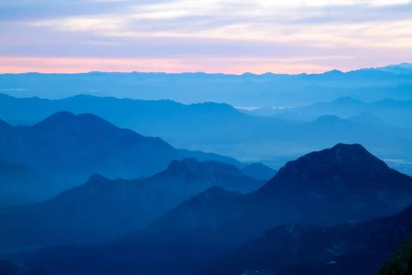 Mavi sis ve bulutlar (gün batımı veya günbatımı ile uzak Dağları)