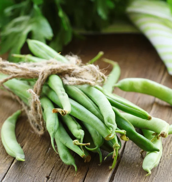 Biologische groene bonen op een houten tafel — Stockfoto