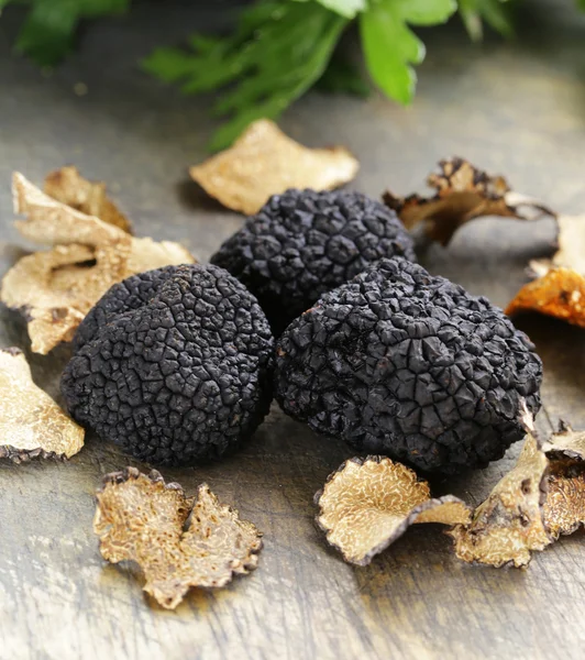 Изысканный гриб черный трюфель свежий и сухой на деревянном фоне Лицензионные Стоковые Изображения