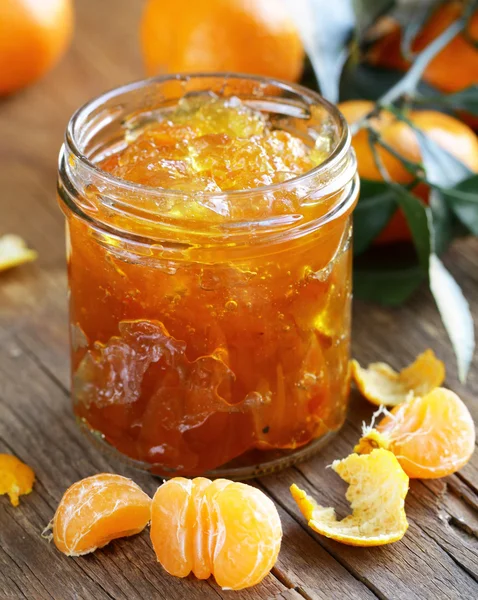 Dżem z owoców cytrusowych mandarin w szklanym słoju na drewnianym stole — Zdjęcie stockowe