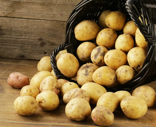 Natural organic raw potatoes on a wooden table — Stock Photo, Image