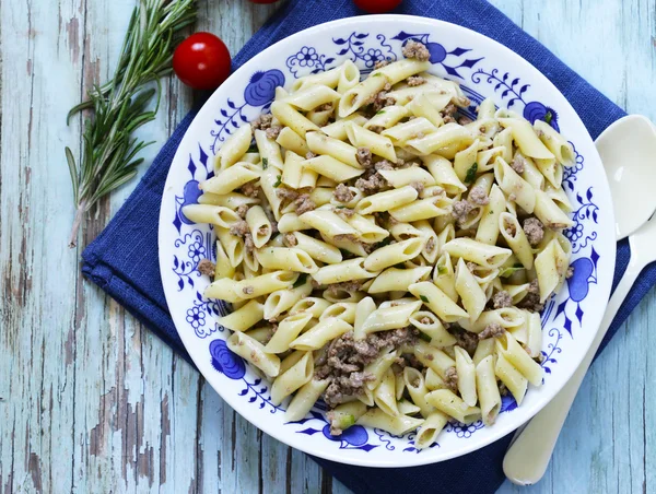 Massa penne com carne e ervas em uma mesa de madeira — Fotografia de Stock