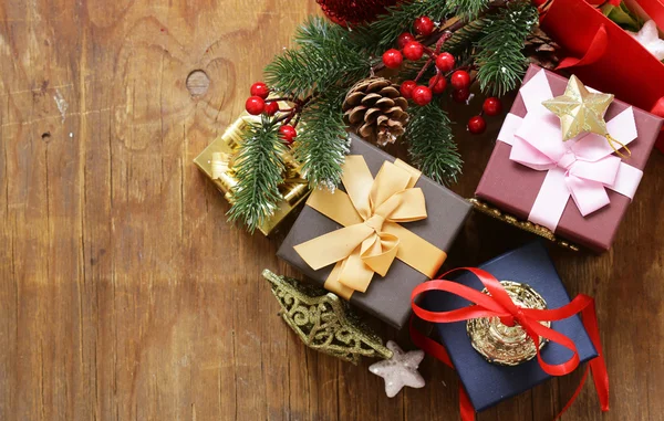 Karácsonyi ajándékok és díszek, a fából készült háttér, ünnepi csendélet — Stock Fotó