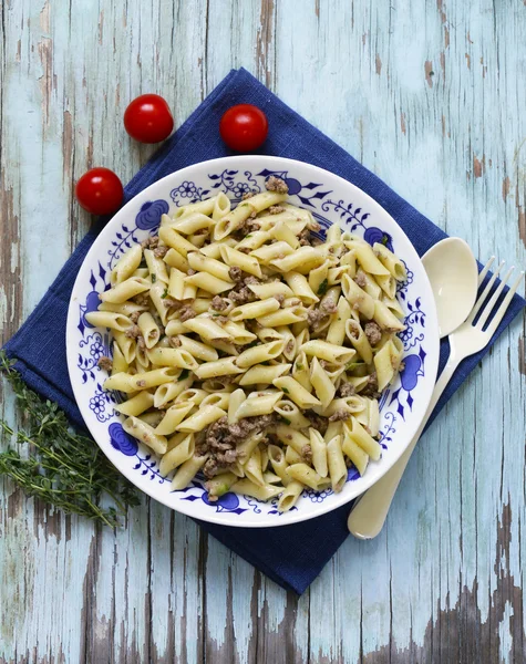 Massa penne com carne e ervas em uma mesa de madeira — Fotografia de Stock