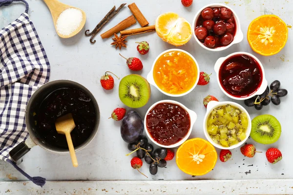 Surtido de bayas y mermeladas de frutas. Enlatado casero. Bayas y frutas frescas — Foto de Stock