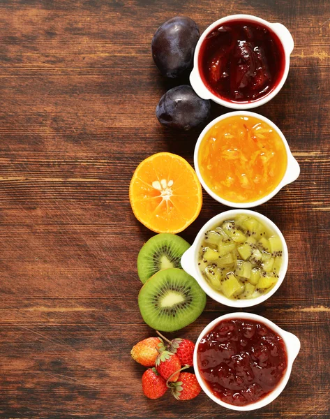 Surtido de bayas y mermeladas de frutas. Enlatado casero. Bayas y frutas frescas —  Fotos de Stock