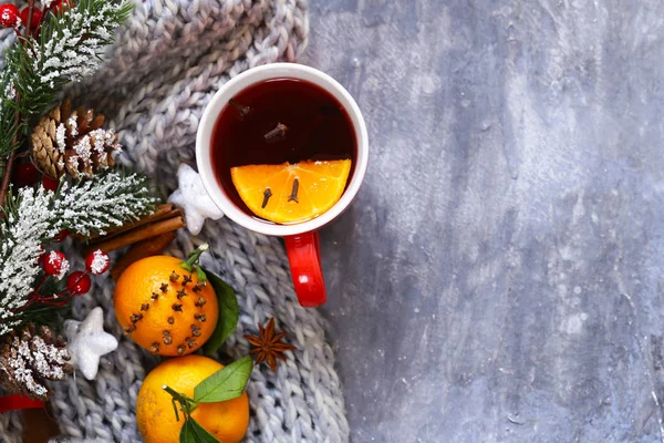 Bebida tradicional de invierno vino caliente con especias. Bebida de Navidad. Fondo gris con bufanda de punto — Foto de Stock