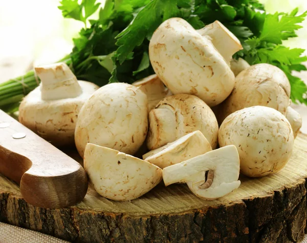 Натуральные органические грибы шампиньоны на деревянном столе — стоковое фото