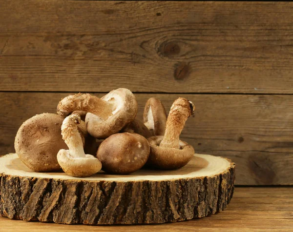 Натуральные органические грибы шампиньоны на деревянном столе — стоковое фото