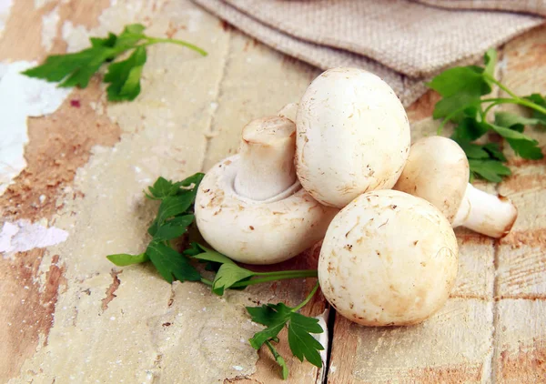 Natural organic raw mushrooms champignons on a wooden table — Stock Photo, Image