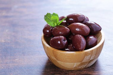 Kırmızı kalamata zeytin ahşap bir masa üzerinde