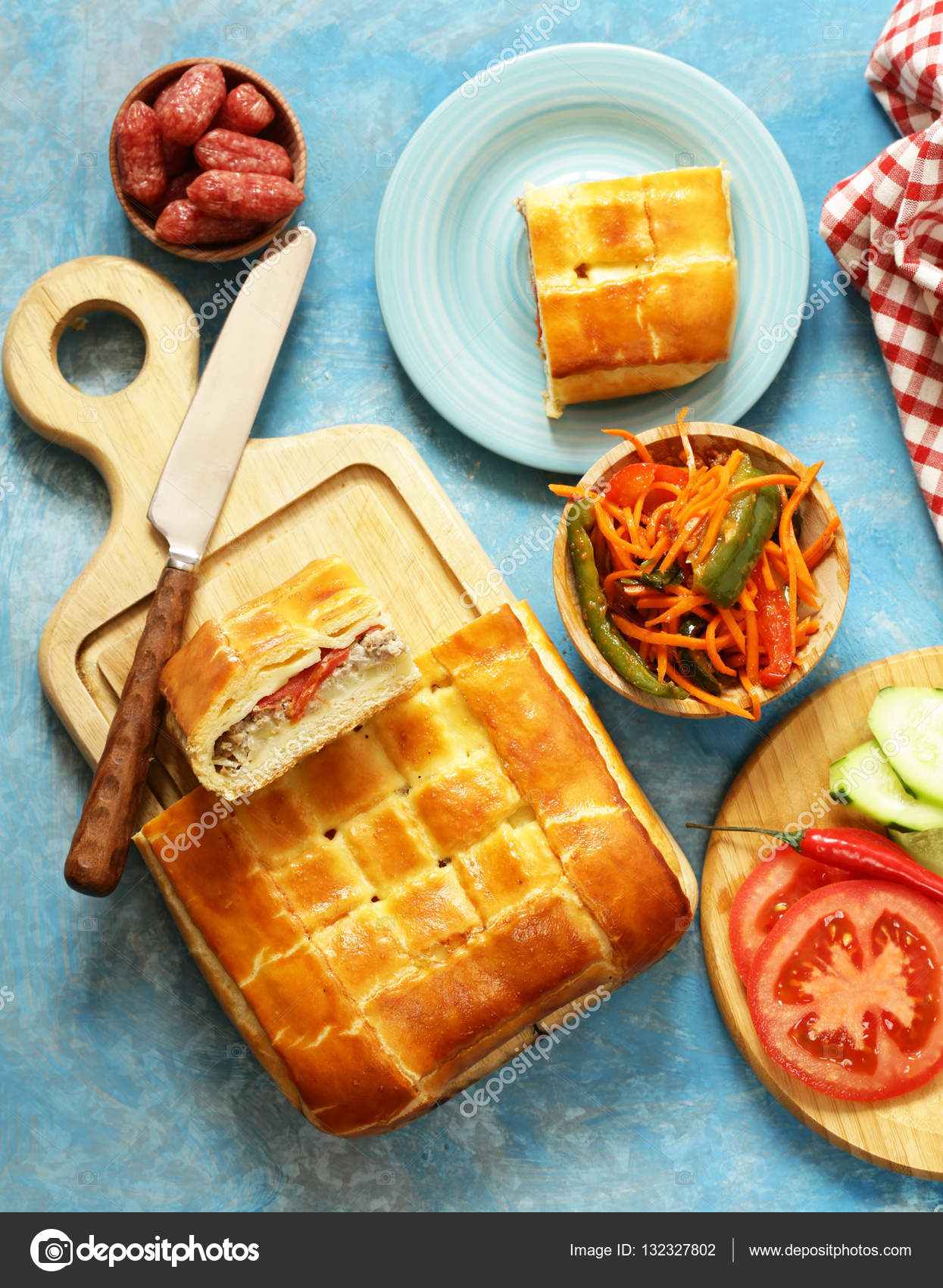 Lunch picnic table homemade meat pie with salad and salami, top view