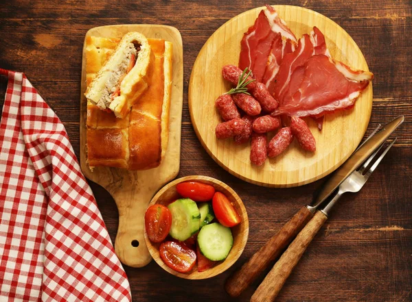 Mesa de piquenique de almoço torta de carne caseira com salada e salame, vista superior — Fotografia de Stock