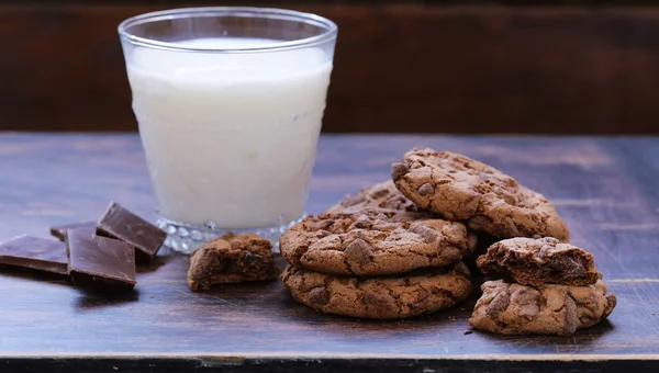 Kekse mit Schokoladenstücken auf einem Holztisch — Stockfoto