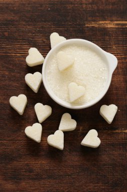 Toz şeker ve kalp şeklinde bir ahşap arka plan üzerinde siyah zemin