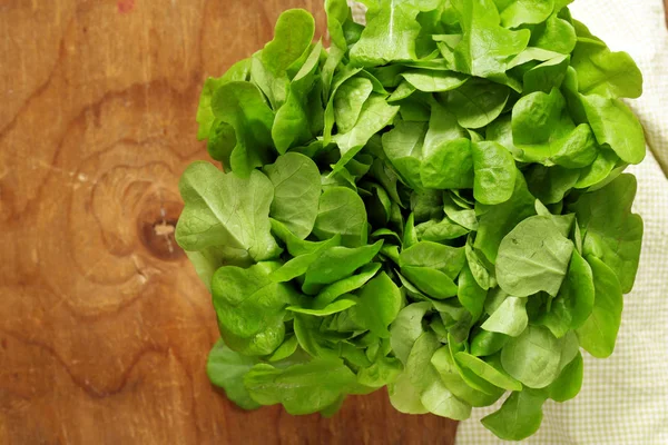 Fresh natural organic green salad leaves on a wooden table — Stock Photo, Image