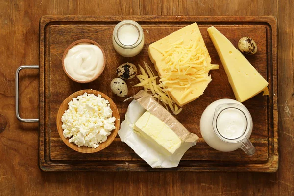 Productos lácteos variados (leche, yogur, requesón, crema agria) bodegón rústico — Foto de Stock