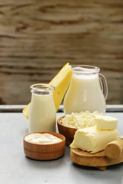 Prodotti lattiero-caseari assortiti (latte, yogurt, ricotta, panna acida) natura morta rustica — Foto Stock