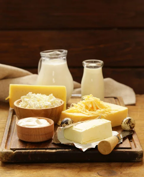 Çeşitli süt ve süt ürünleri (süt, yoğurt, peynir, ekşi krema) rustik natürmort — Stok fotoğraf