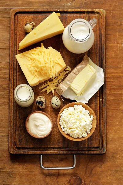 Produits laitiers variés (lait, yaourt, fromage cottage, crème sure) nature morte rustique — Photo