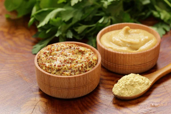 Натуральная горчица, приправа и соус на деревянном столе — стоковое фото