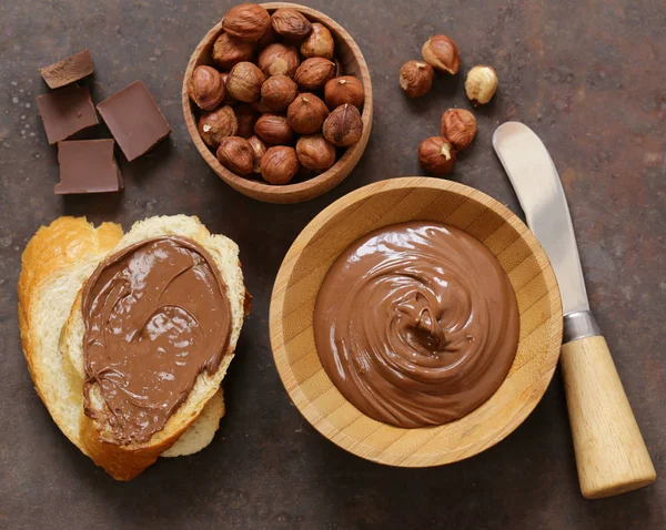 Pasta czekoladowa rozprzestrzeniania z orzechów laskowych i chleb na śniadanie — Zdjęcie stockowe