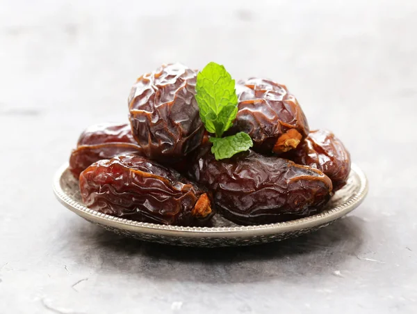 Higos secos dulces dátiles en un plato sobre la mesa — Foto de Stock