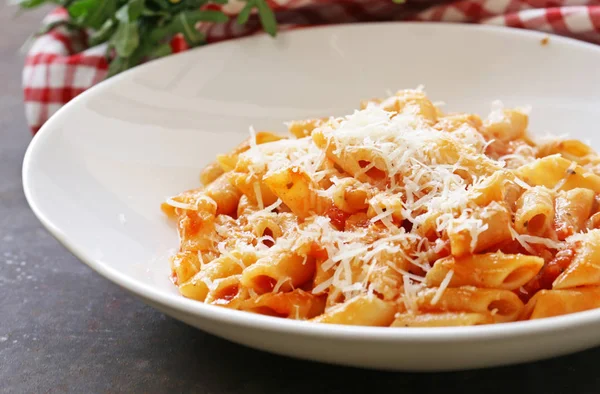 Massa penne com molho de tomate em uma placa branca — Fotografia de Stock