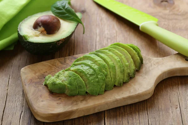 Здоровое питание - спелый авокадо на деревянной доске — стоковое фото