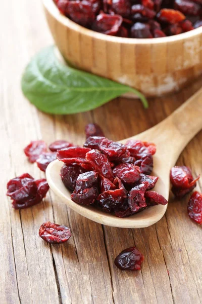 Bagas secas cranberries vermelhas em uma mesa de madeira — Fotografia de Stock