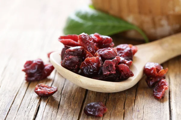 Bagas secas cranberries vermelhas em uma mesa de madeira — Fotografia de Stock