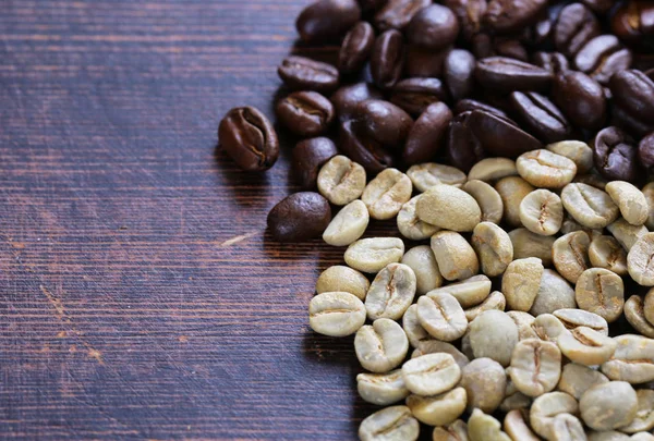 木制的背景上的绿色和棕色的咖啡豆 — 图库照片