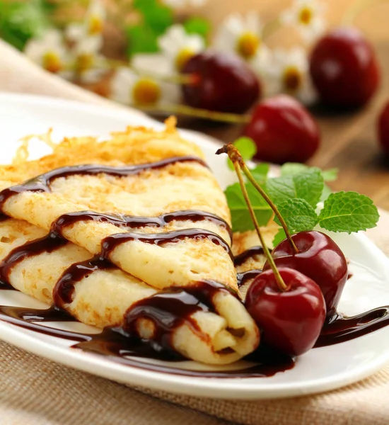 Thin pancake with chocolate syrup and berries — Stock Photo, Image