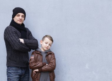 Adam ve çocuk (baba ve oğul) gri bir arka plan üzerinde poz