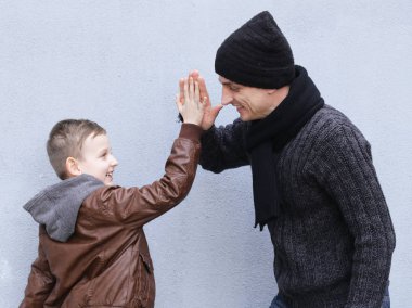 Adam ve çocuk (baba ve oğul) gri bir arka plan üzerinde poz