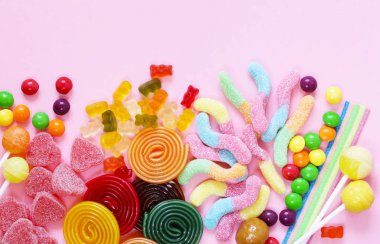 Pembe bir arka plan üzerinde renkli şeker ve meyve jöle hünnap