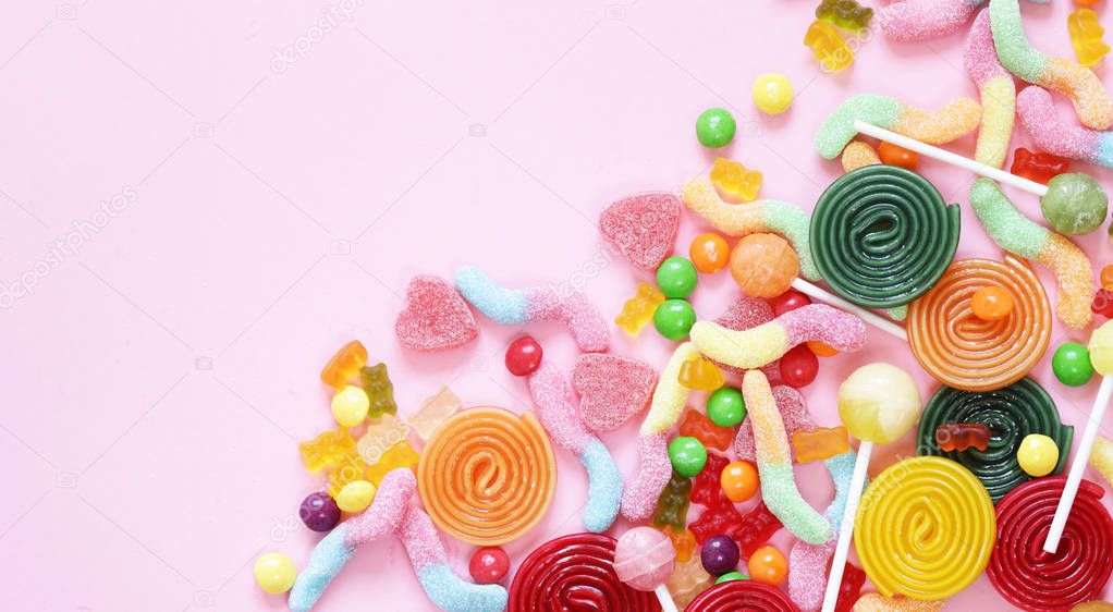 Colorful candy and fruit jelly jujube on a pink background