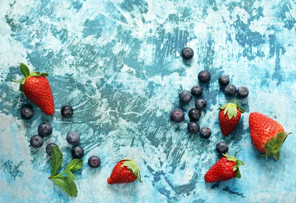 Fresas y arándanos sobre fondo de hierro azul —  Fotos de Stock