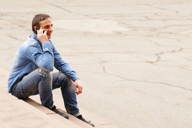 Cep telefonu açık olan yakışıklı genç adam