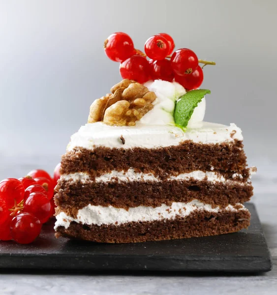 Um pedaço de bolo com bagas e creme cremoso - uma deliciosa sobremesa — Fotografia de Stock