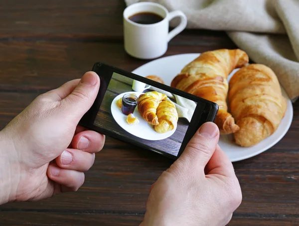 Frukost croissant med kaffe - foto på telefon — Stockfoto