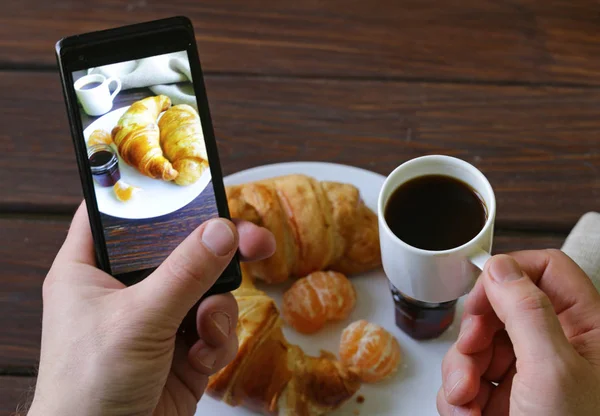 Croissant di colazione con caffè - fotografia su telefono — Foto Stock