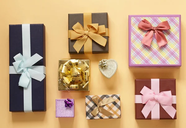 A lot of gift boxes with bows on a beige background — Stock Photo, Image