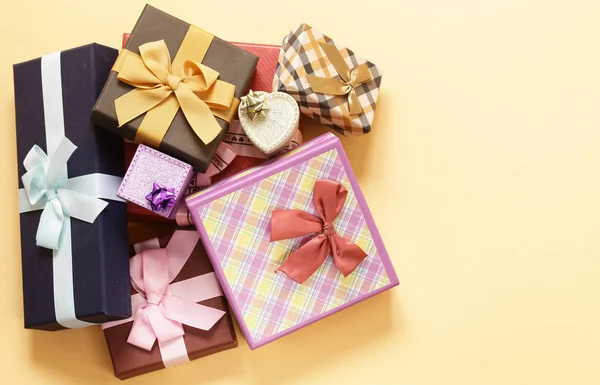 Un sacco di scatole regalo con fiocchi su sfondo beige — Foto Stock