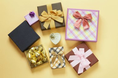 Bir sürü hediye kutuları ile bej renkli arka plan üzerinde yay