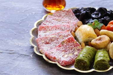 Doğu tatlılar (baklava, rahat loachum) ve gümüş tabakta kuru meyveler