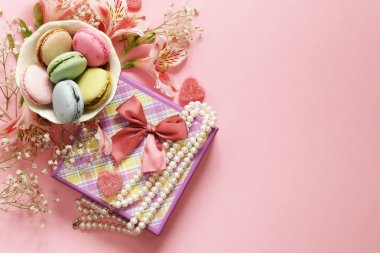 çiçekler ve pembe bir arka plan üzerinde macaroons