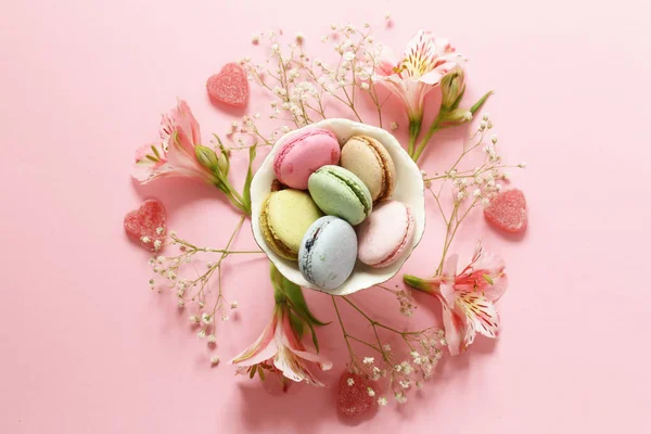 Flores e macaroons em um fundo rosa — Fotografia de Stock