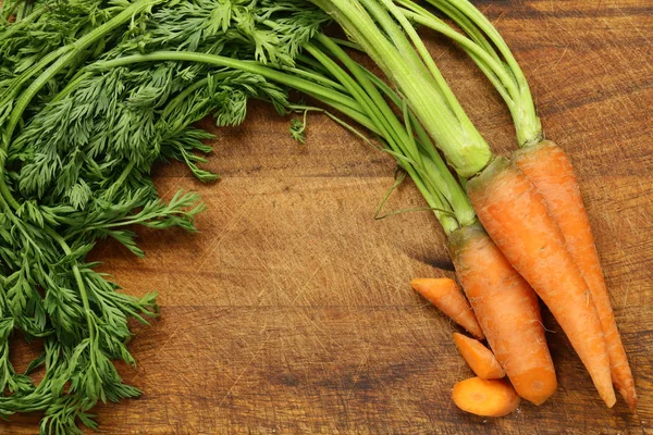 Natural organic carrots on a wooden background — Stock Photo, Image