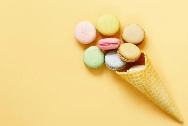 Macaroons de biscoitos de amêndoa coloridos em um cone de waffle — Fotografia de Stock